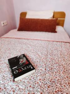 un libro sentado en la parte superior de una cama en Evaggelia's Apartments 5 Οικογενειακό Διαμέρισμα, en Kozani