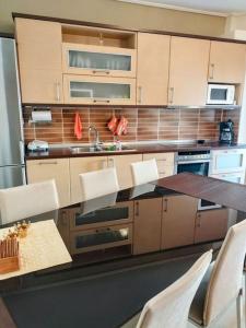 cocina con mesa, sillas y encimera en Evaggelia's Apartments 5 Οικογενειακό Διαμέρισμα, en Kozani