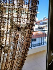cortina en una ventana con vistas a un balcón en Evaggelia's Apartments 5 Οικογενειακό Διαμέρισμα, en Kozani