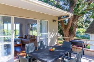 a patio with a table and chairs and a couch at Wilderness Holiday Home - Riverside in Wilderness