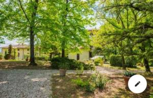een tuin met bomen en een huis met een frisbee bij Residenza privata Paradiso in Sansepolcro