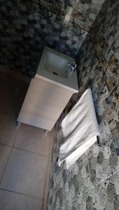 ein Badezimmer mit einem Waschbecken und einem Handtuch auf dem Boden in der Unterkunft Gite Aguelmous réservé aux familles 