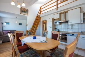 a kitchen and dining room with a wooden table and chairs at Ferienwohnung Ostseecharme Rei in Ostseebad Karlshagen