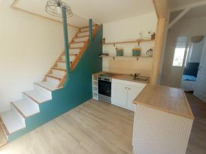 eine Küche mit einer Wendeltreppe in einem Zimmer in der Unterkunft Appartement en bordure de forêt in Cransac