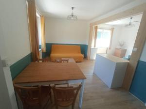 Zimmer mit einem Tisch, Stühlen und einem Sofa in der Unterkunft Appartement en bordure de forêt in Cransac