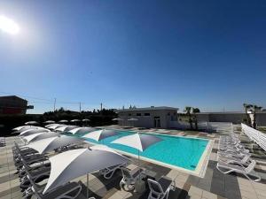 a row of chairs and a swimming pool with umbrellas at PoolSide in Irsina