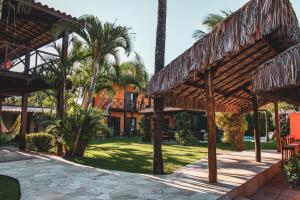 un complejo con palmeras y un patio en Pousada Meeting Point & KiteSchool en Cumbuco