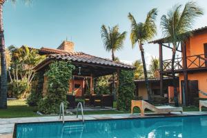 a house with a swimming pool in front of a house at Pousada Meeting Point & KiteSchool in Cumbuco