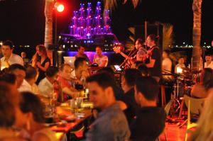 a group of people sitting at a bar at night at Yunus Beach Hotel in Marmaris +93 photos