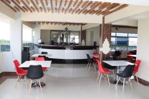 a restaurant with white tables and red chairs at Paraiso Gardens Hotel in Wote