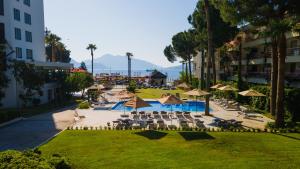 a resort with chairs and umbrellas and a pool at Hotel Caprea in Marmaris