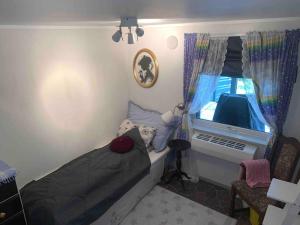 een kleine slaapkamer met een bed en een raam bij Privat soverom in Moss