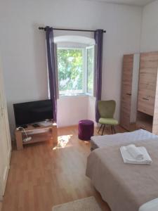 a bedroom with two beds and a flat screen tv at Studio Apartman Ivanka in Orebić