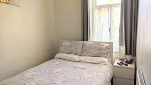 un dormitorio pequeño con una cama con flores rosas. en New Holiday Let in Skipton, North Yorkshire, en Skipton