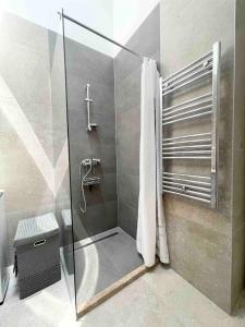 um chuveiro com uma porta de vidro na casa de banho em Golden Pearl em Mostar