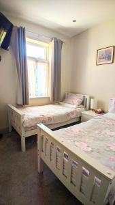 - une chambre avec 2 lits et une fenêtre dans l'établissement New Holiday Let in Skipton, North Yorkshire, à Skipton