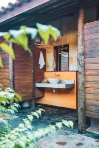 Baño de color naranja con lavabo y espejo en Pousada Meeting Point & KiteSchool en Cumbuco
