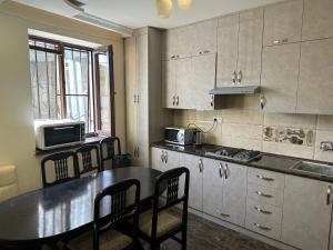 a kitchen with a table and chairs and a microwave at FAVORIT HOTEL-HOSTEL in Yerevan