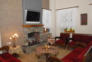 a living room with a fireplace and a tv at Hotel Filoxenia in Portariá