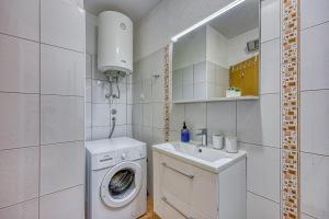 a white bathroom with a washing machine and a sink at Holiday Apartment Stojanovski in Rovinjsko Selo