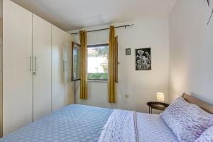 a bedroom with a bed and a window at Holiday Apartment Stojanovski in Rovinjsko Selo