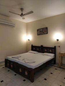 Łóżko w sypialni z wentylatorem sufitowym w obiekcie Rigmor haveli w mieście Dźodhpur