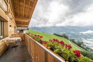 einen Balkon mit Blumen und Bergblick in der Unterkunft Waldes Duft Wohnung - Patleidhof in Naturns