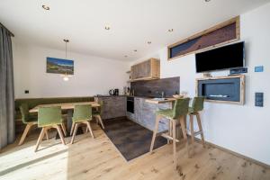 een keuken en eetkamer met een tafel en stoelen bij Waldes Duft Wohnung - Patleidhof in Naturno