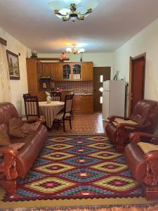 un soggiorno con divani e tavolo e una cucina di Guesthouse Space a Përmet