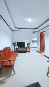 een woonkamer met een bank en een tv bij YZRAJ Homestay in El Nido