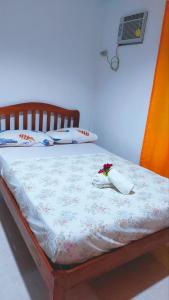 a bedroom with a bed with flowers on it at YZRAJ Homestay in El Nido