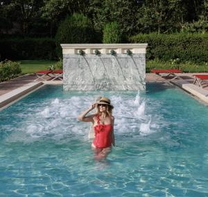 Eine Frau, die im Pool im Wasser steht. in der Unterkunft QC Termeroma Spa and Resort in Fiumicino