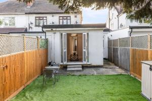 a small yard with a fence and grass at Stunning 2 Bedroom House with Garden BBQ - Hampstead Heath Park in London