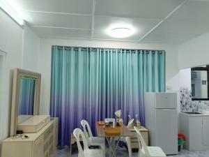a kitchen with a table and a blue curtain at Ontrack Travel in Male City