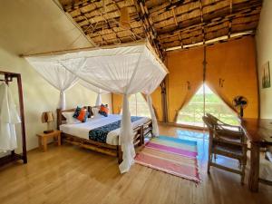 a bedroom with a bed with a canopy at Murchison Falls Bamboo Village in Murchison Falls National Park