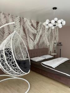 ein Schlafzimmer mit einem Bett und einer hängenden Hängematte in der Unterkunft Квартира Тропики центр міста st Remisnycha 55a in Tschernihiw