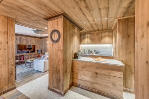 a kitchen with wood paneled walls and a counter at Appartement CHEVRIL à l'Hôtel LE VAL D'ISERE in Val dʼIsère +22 photos