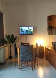 a dining room with a table and a television on the wall at The house of ZORBAS in Agios Vlasios