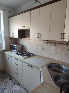a kitchen with white cabinets and a sink at Pokoje_Zbąszyń in Zbąszyń +22 photos