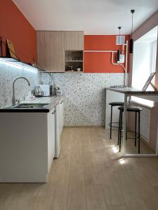 uma cozinha com armários laranja e branco e uma mesa em Квартира Тропики центр міста st Remisnycha 55a em Chernigov