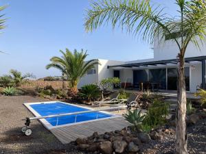 una villa con piscina e una casa di Majanicho Rock - villa with heated pool a Lajares