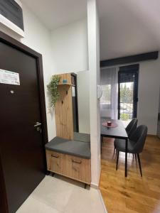 a kitchen and dining room with a table and a door at Theos apartman Titova vila in Zlatibor