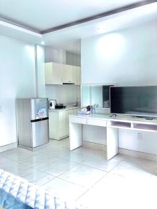 Il comprend une cuisine blanche équipée d'un réfrigérateur et d'un comptoir. dans l'établissement Hotel Nam Sơn, à An Khê