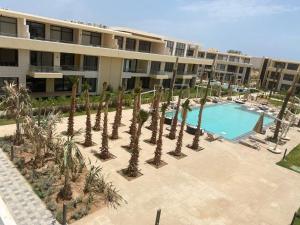 an apartment complex with a swimming pool and palm trees at Studio EL Gouna G-Cribs in Hurghada