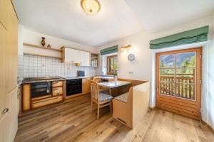 a kitchen with wooden floors and a table and chairs at Ferienhaus Engele in San Martino