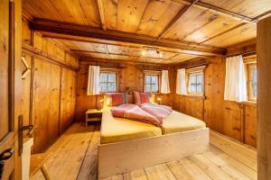 a bedroom with a bed in a room with wooden walls at Ferienhaus Engele in San Martino