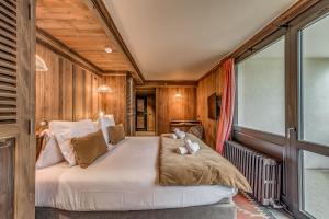 a large bed in a room with wooden walls at Appartement CHEVRIL à l'Hôtel LE VAL D'ISERE in Val dʼIsère
