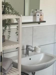 a white bathroom with a sink and a mirror at Falkenhof Meisdorf in Meisdorf