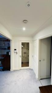ein Zimmer mit weißen Wänden und einem Flur mit Türen in der Unterkunft Enchantia Stayz: Central London's Exquisite Abodes in London