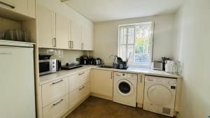 eine Küche mit Waschmaschine und Trockner in der Unterkunft Enchantia Stayz: Central London's Exquisite Abodes in London